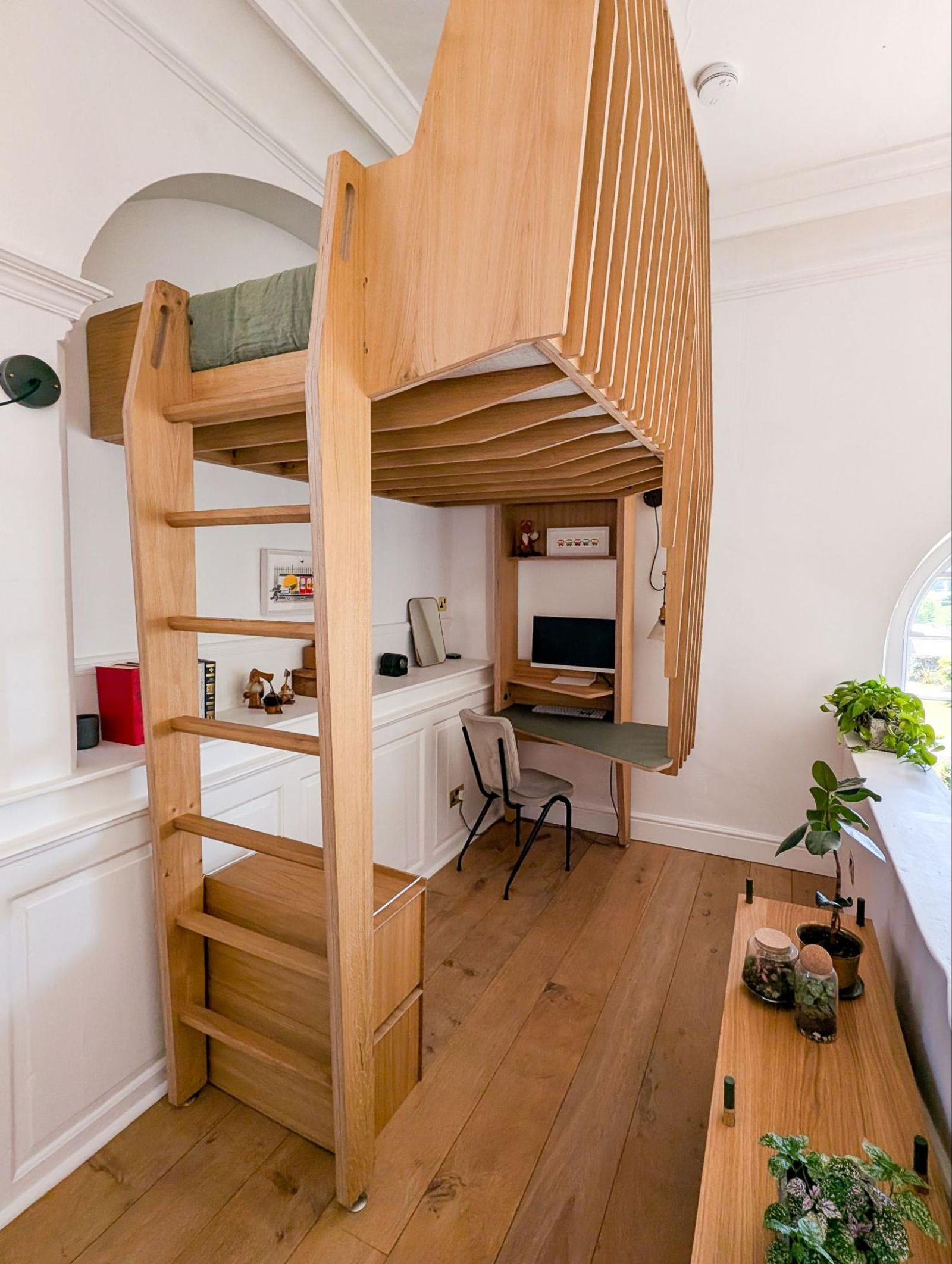 Image showing a lifted wood twin-sized bed frame and desk designed by Future Joinery Systems.