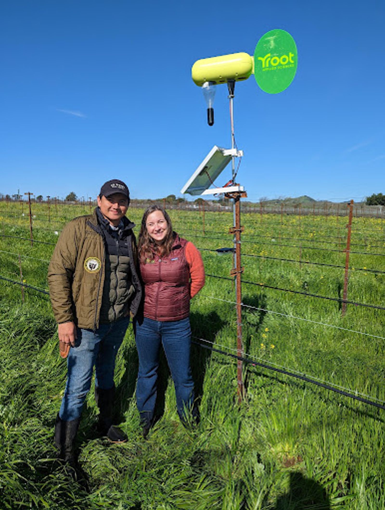Root CEO Sarah Placella stands in a vineyard with the owner.