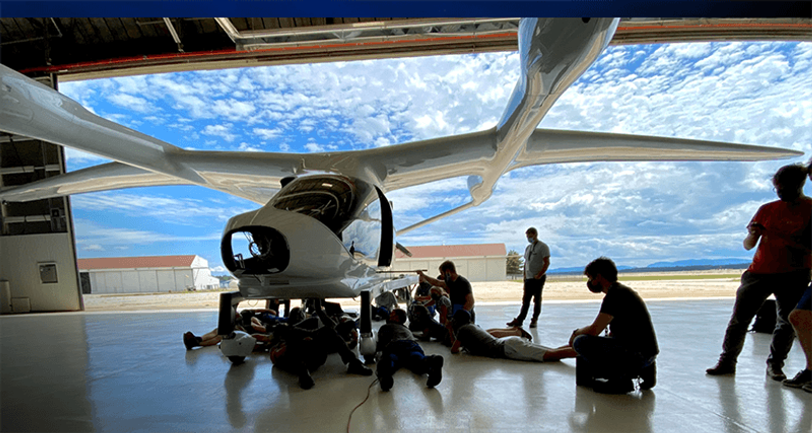 Leute schauen sich BETA-Flugzeuge im Hangar an