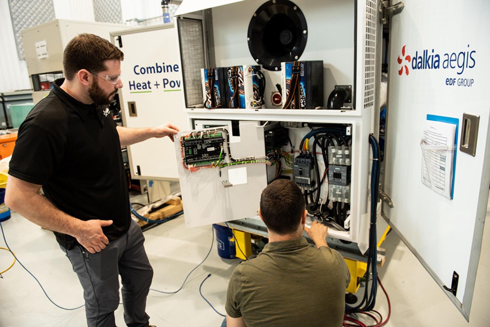 two Dalkia workers inspecting machine
