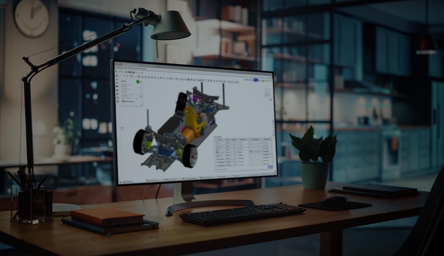 Darkened stock image of a desk with a computer monitor with a CAD model in Onshape.