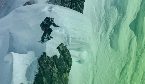 A person snowboarding off a mountain
