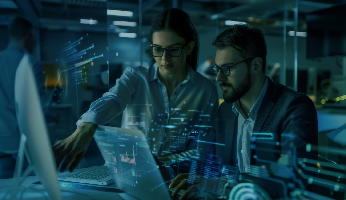 Darkened hero stock image showing two coworkers in a tech environment.