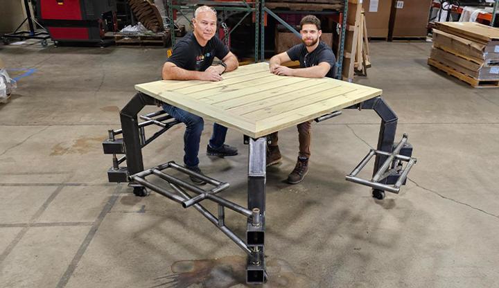 Image showing two engineers testing out the finished inclusive picnic table.