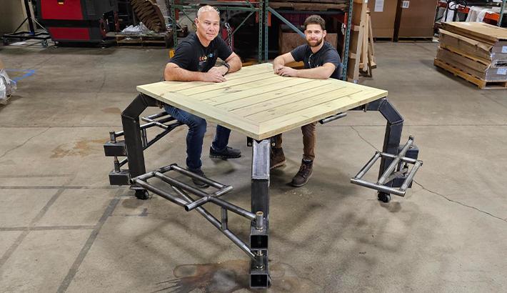 Image showing two engineers testing out the finished inclusive picnic table.