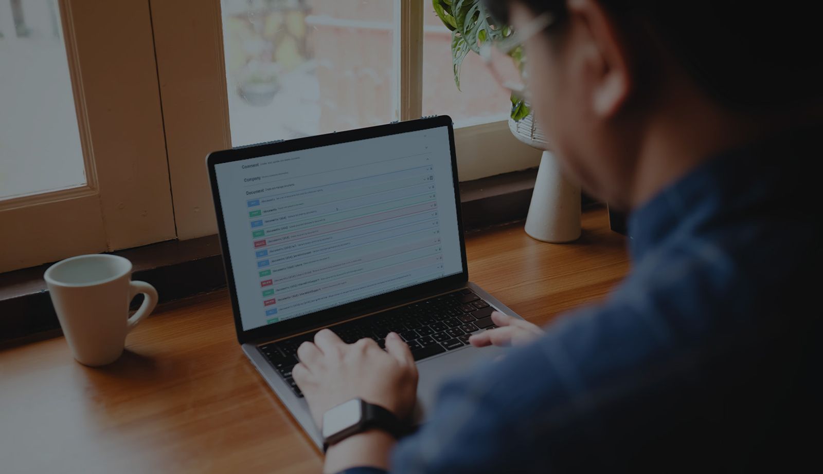 Stock image darkened with an overlay showing someone learning about Onshape API on a laptop.