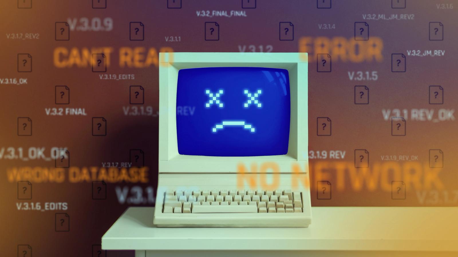 Stock image of an old-school computer with a sad face on the screen.