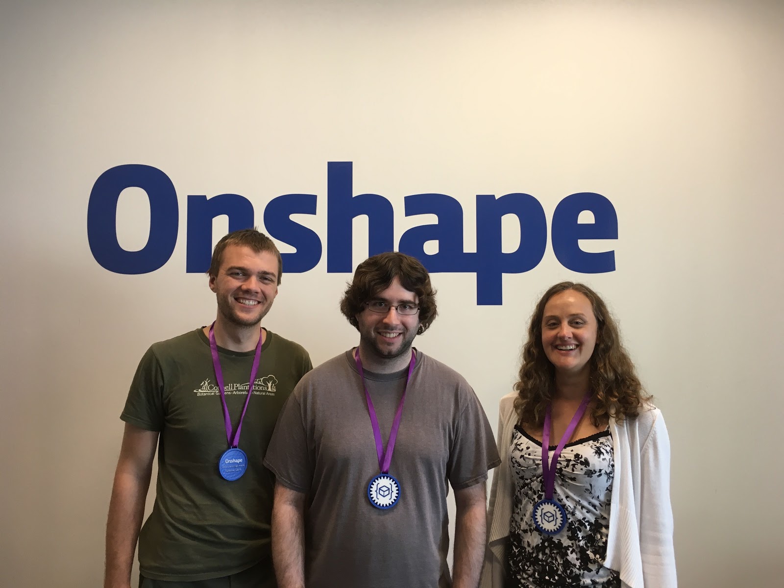 Photo of Onshape engineers Ethan Keller, Jon Sorrells and Kori Ryter wearing their winner's medals for winning Onshape's 2019 Custom Feature Hackathon.